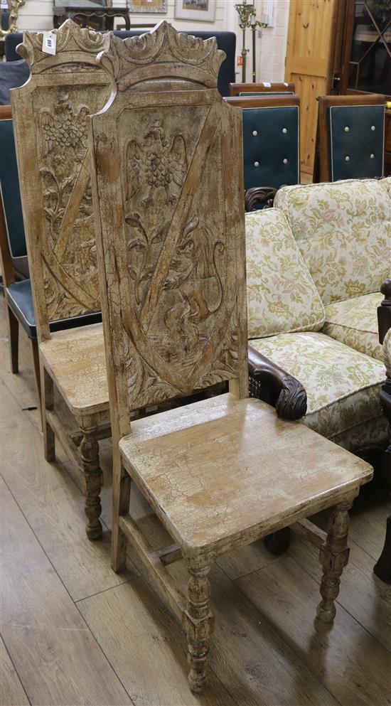 A pair of painted high back chairs, the panels carved with eagles and lions